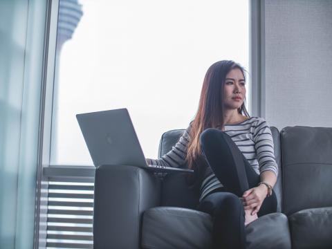 a girl sitting on the sofa with her computer.