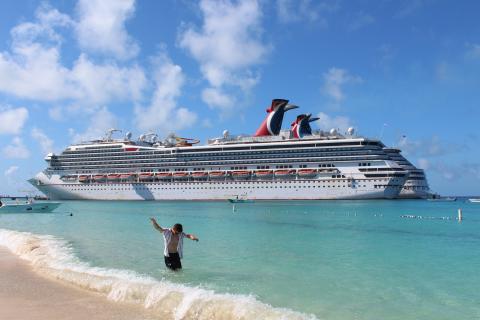 a man in the water in front of a cruise ship