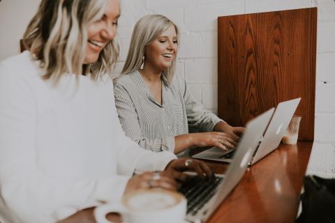 two women are working on computer