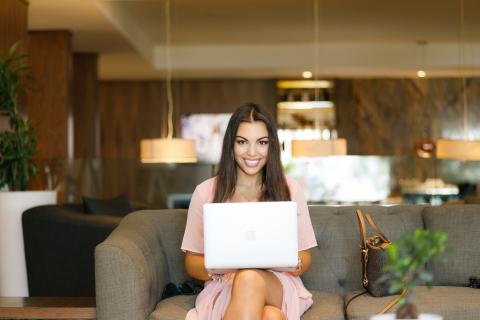 a girl sitting on the sofa with her laptop