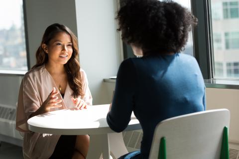 two girls are speaking at the table