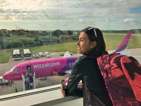 a girl at the airport looking at the airplane