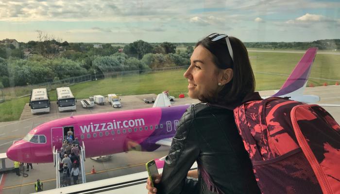 a girl at the airport looking at the airplane
